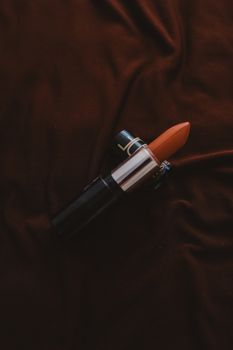 Close-up of a red lipstick on a rich velvet texture, exuding classic elegance.