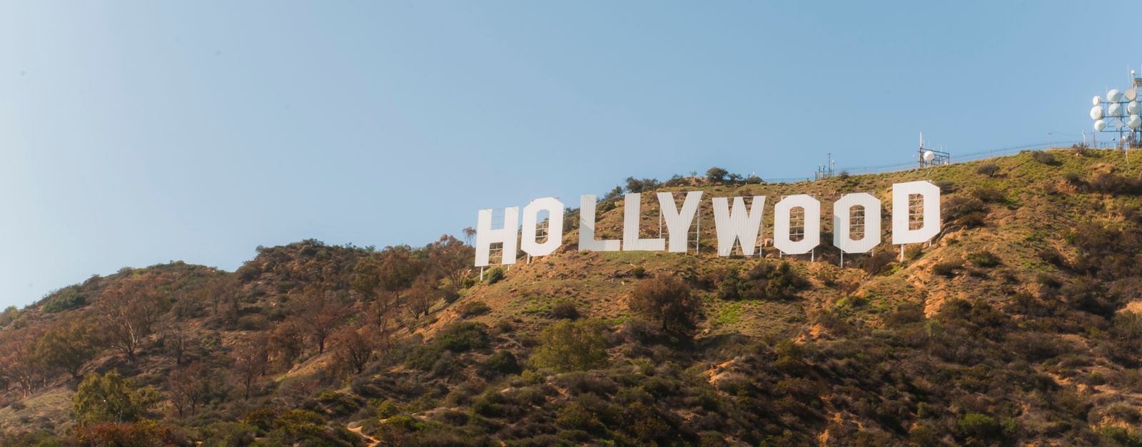 Famous Hollywood Sign on hillside under clear blue sky in Los Angeles, California.