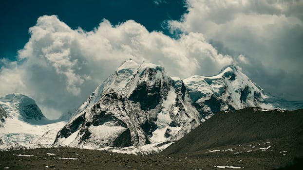 Stunning snow-covered peaks under a dramatic sky in Sikkim, India.