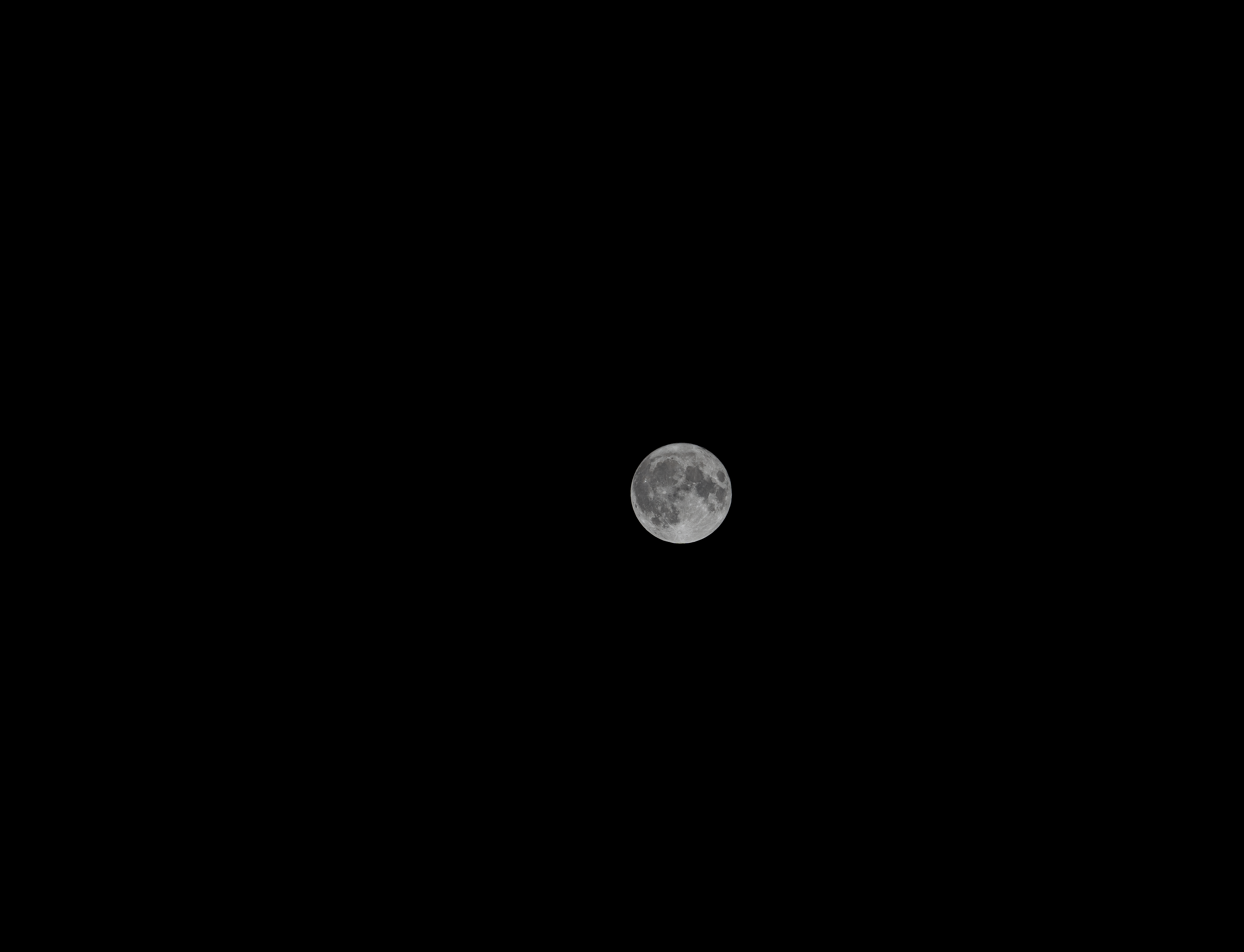 Une photographie claire de la pleine lune sur un ciel sombre, mettant en valeur les détails de la surface.