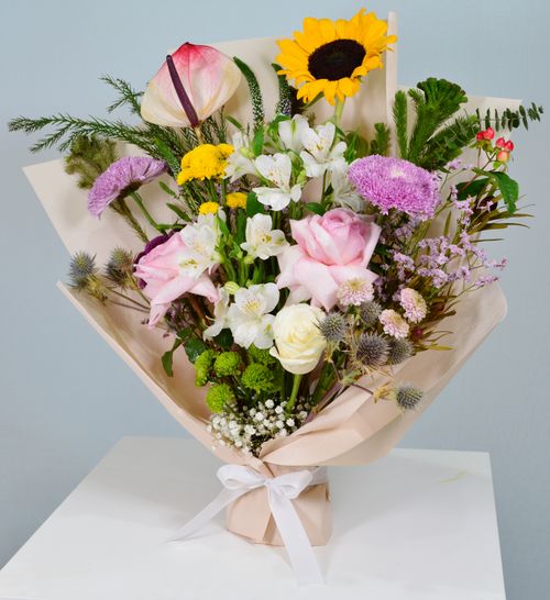Free A colorful bouquet featuring a sunflower, roses, and mixed flowers arranged in Dubai. Stock Photo