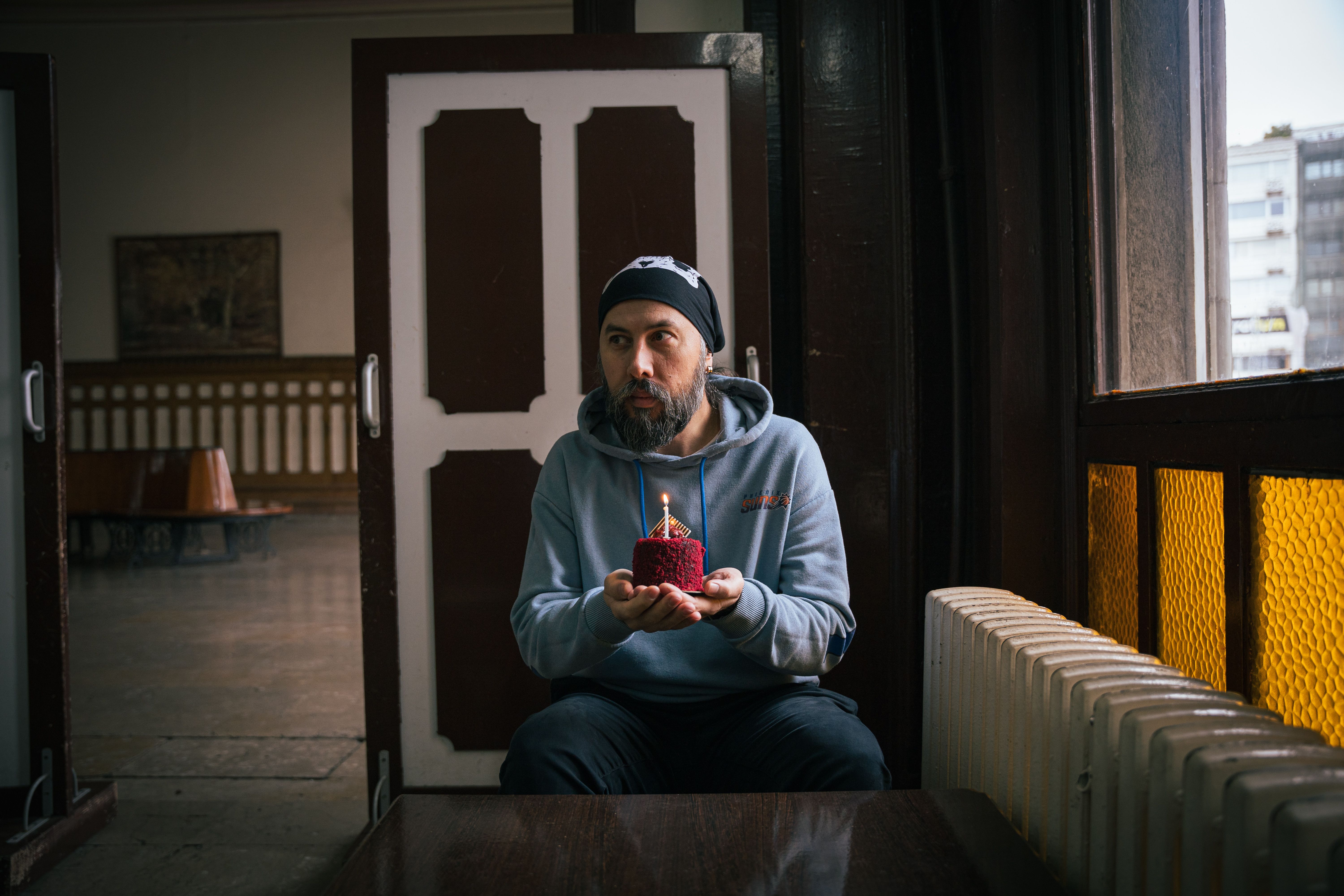 A thoughtful moment with a birthday cake in an Istanbul setting, indoors with warm lighting.