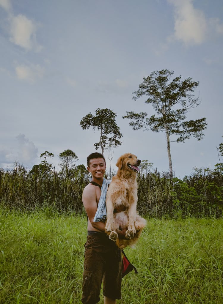 Photo Of Man Carrying Dog