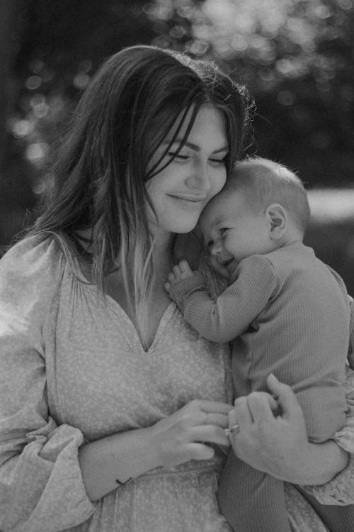 Free Heartwarming black-and-white portrait of a mother and baby embracing outdoors. Stock Photo