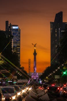 Vibrant sunset at Monumento a la Independencia in Mexico City, highlighting urban architecture.