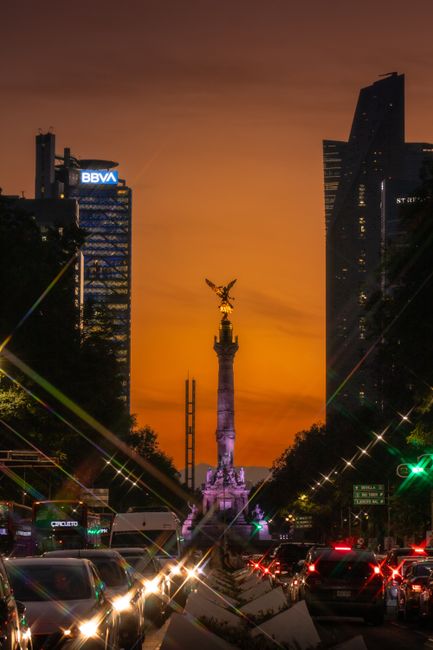 Vibrant sunset at Monumento a la Independencia in Mexico City, highlighting urban architecture.