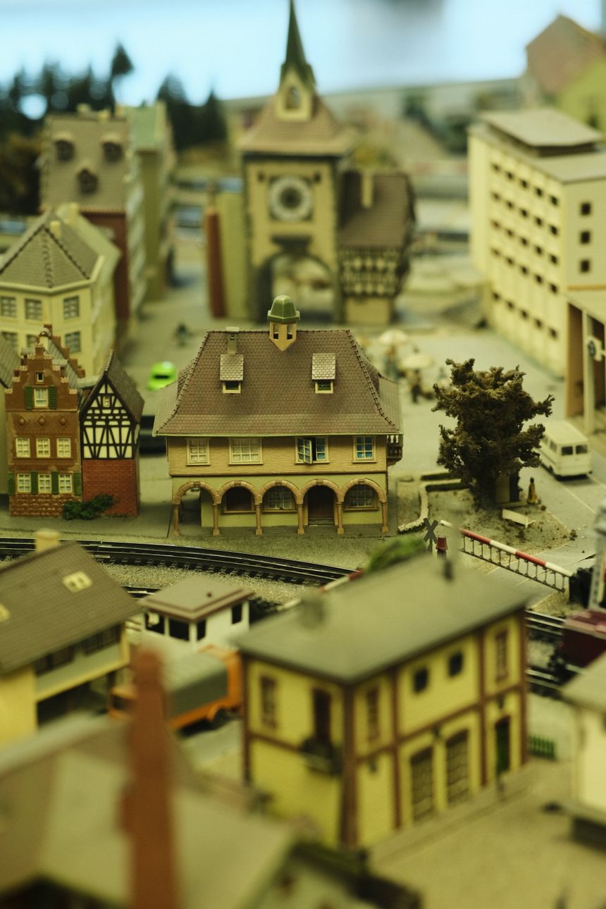 Gameplay clip still: an overhead city-builder board of model townhouses and rail track. Photo by Ramon Karolan on Pexels