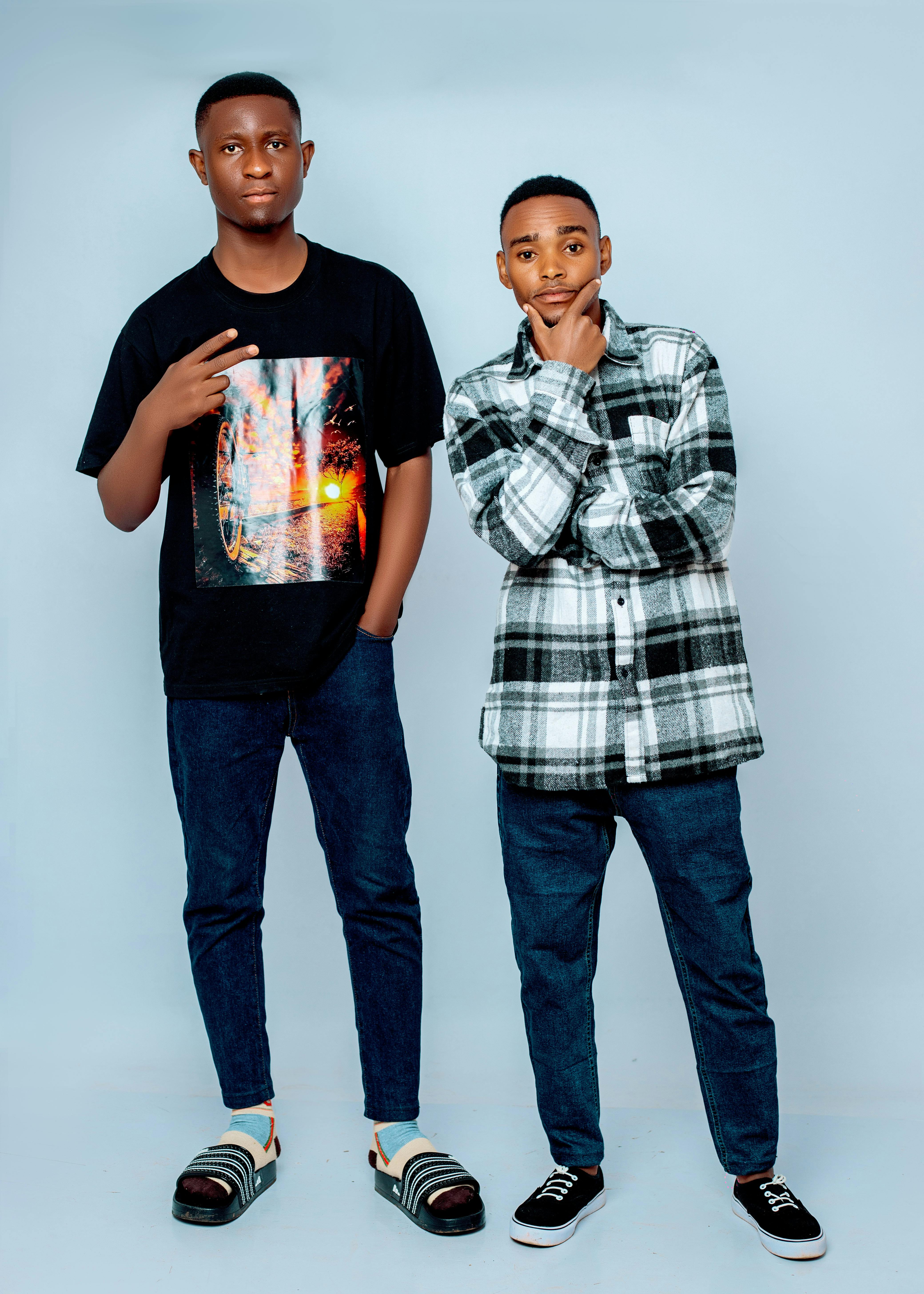 Two young men in casual streetwear pose against a plain background.