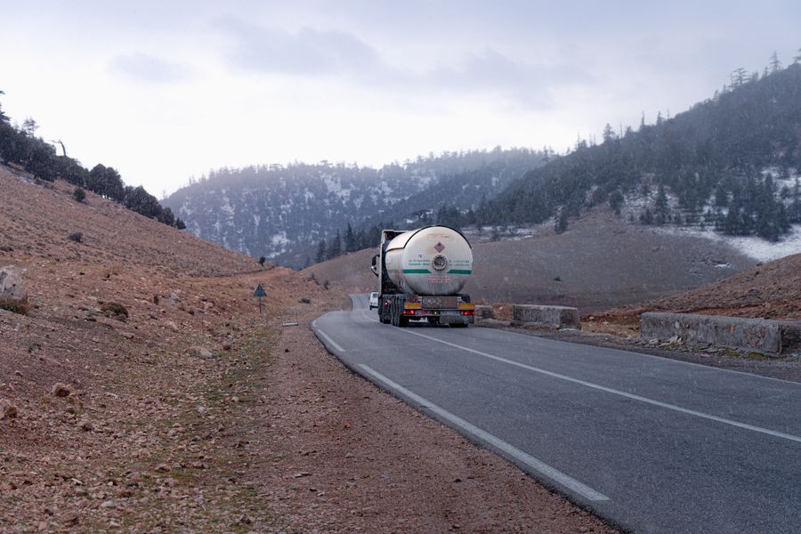 A fuel tanker truck on a snowy mountain road, illustrating winter demand for diesel and heating oil