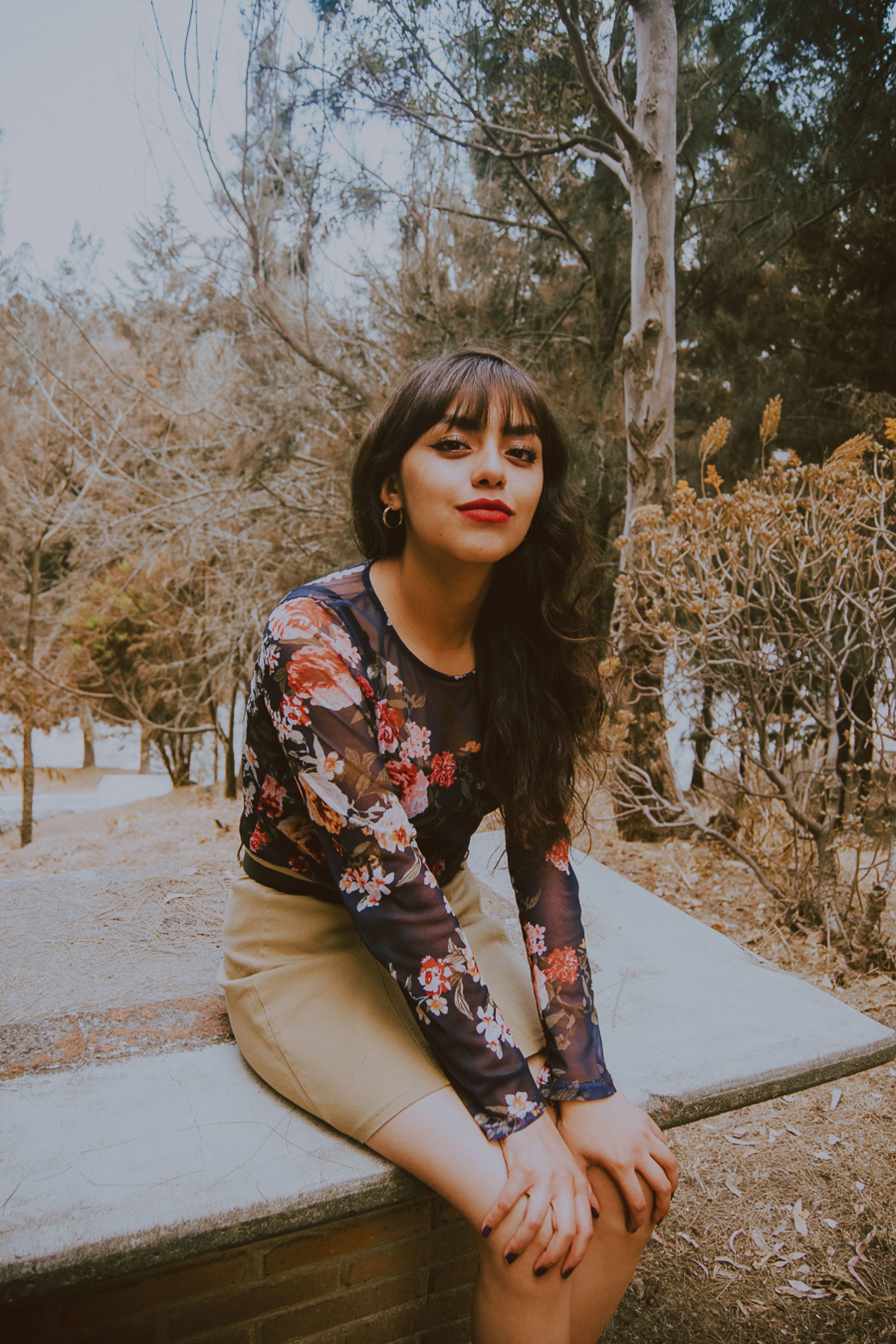 Woman in Floral Top Posing Outdoors in Autumn · Free Stock Photo