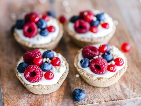 Indulge in these delectable berry tarts topped with fresh raspberries, blueberries, and cream.
