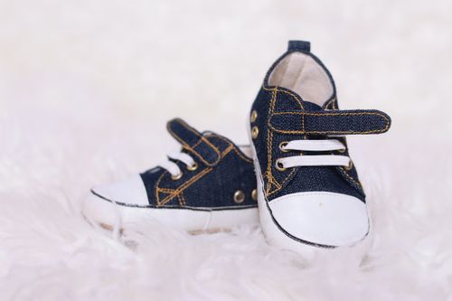 Free Close-up of cute denim baby sneakers on a soft white background, perfect for kids fashion. Stock Photo
