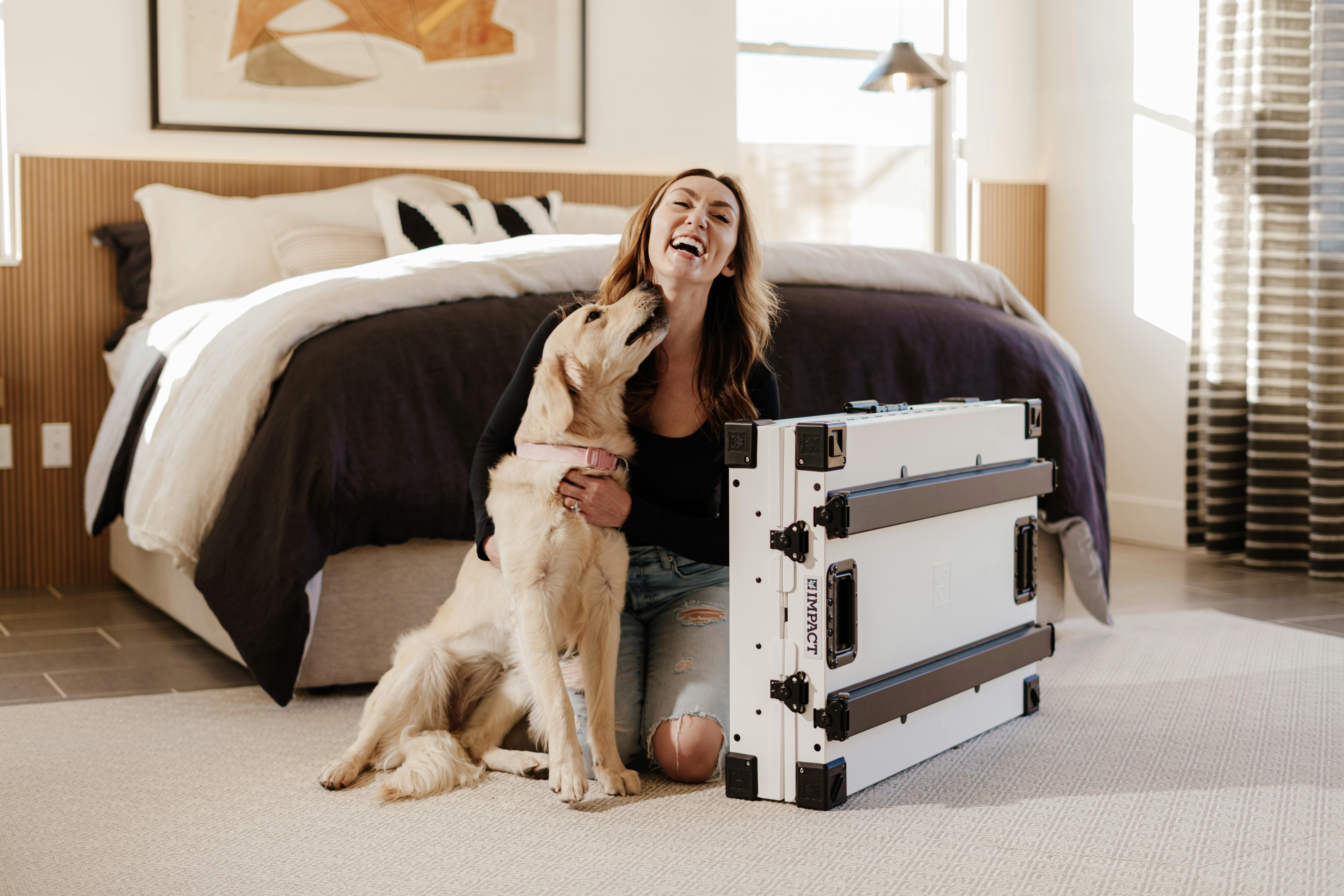 https://www.pexels.com/photo/joyful-woman-with-her-dog-and-smart-crate-in-cozy-bedroom-30268654/