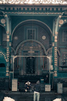 A beautifully decorated historical building with people in winter clothing creating a warm scene.