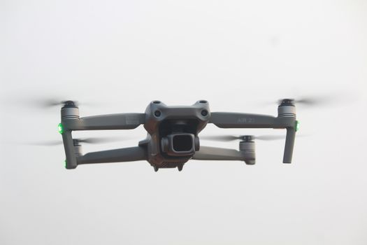 A sleek modern drone captures the moment with precision against a clear sky, showcasing advanced technology.