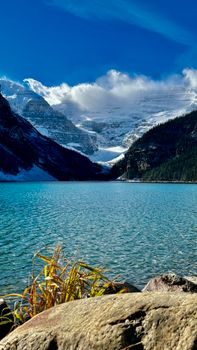 Breathtaking view of Lake Louise surrounded by snow-capped mountains under a clear blue sky.