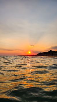 Beautiful sunset view over the sea from Antalya coastline, capturing warm hues and peaceful waves.