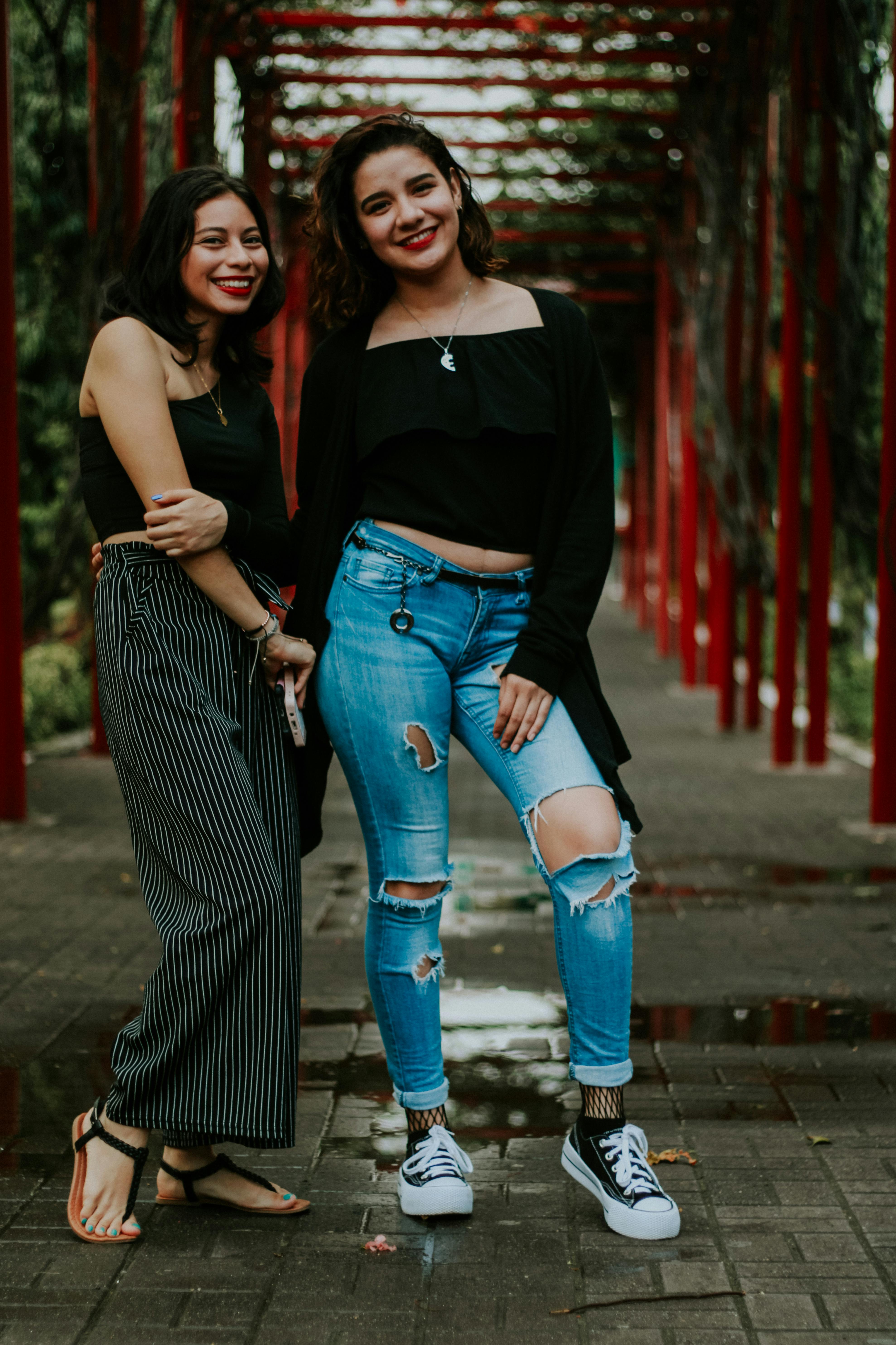 smiling women standing on bridge