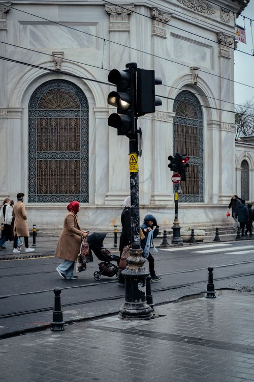 Free People crossing the street at a city intersection by a historic building. Stock Photo