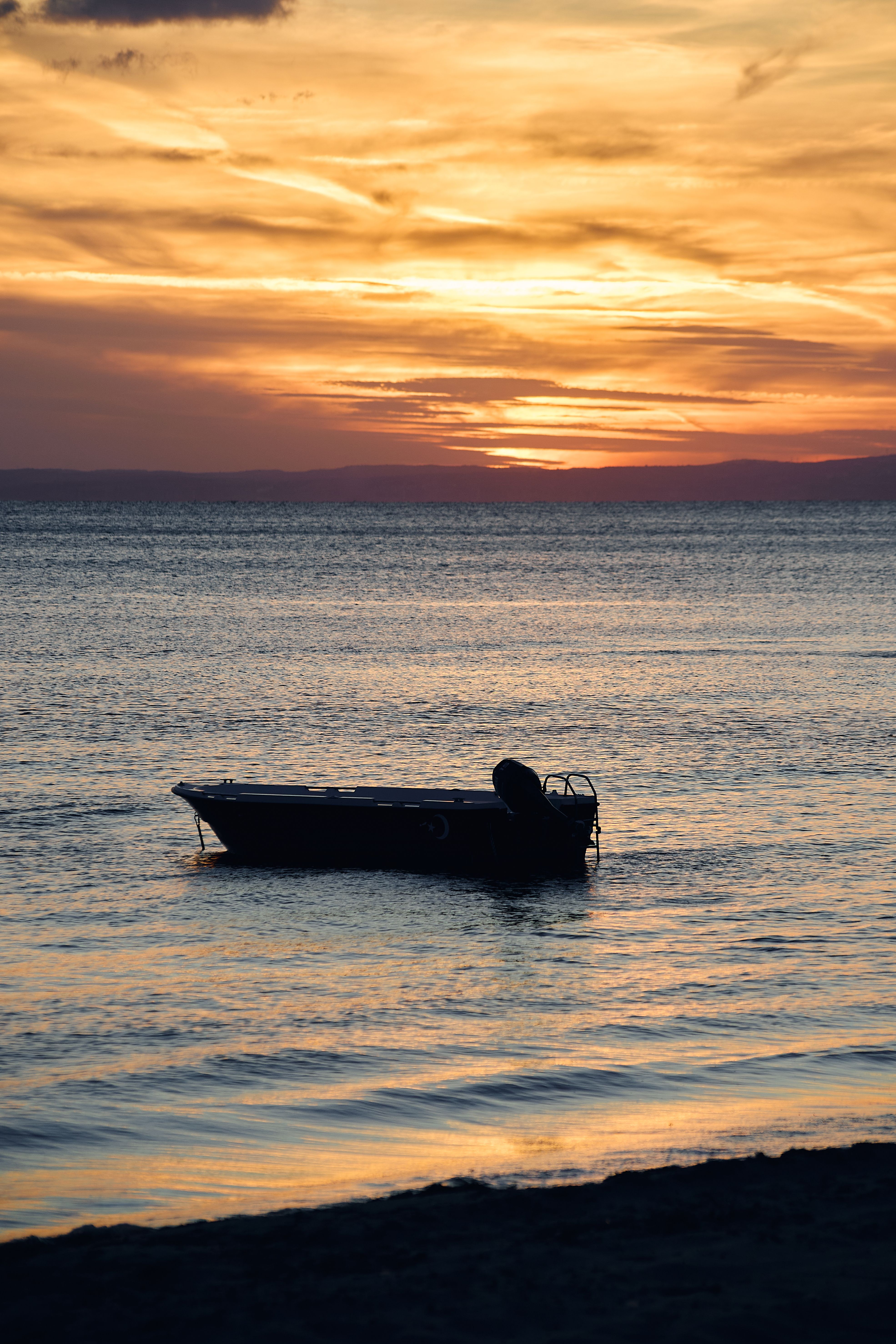 Serene Sunset Boat Silhouette on Calm Sea · Free Stock Photo