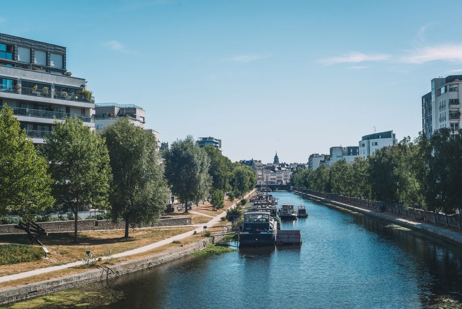 Charmante vue sur la rivière Rennes avec bateaux et bâtiments modernes.