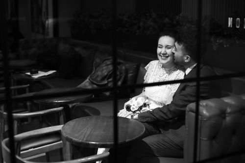 Free A couple sharing a joyous moment in a cozy coffee shop setting. Stock Photo