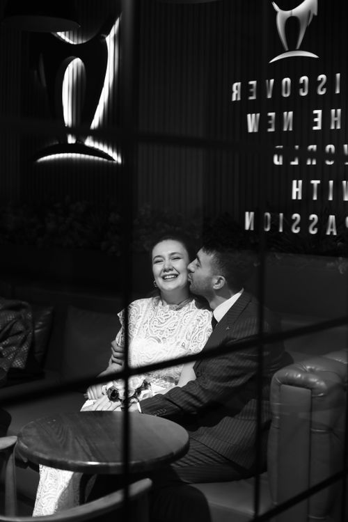 Free A couple enjoying a romantic moment in a cozy cafe, captured in black and white. Stock Photo
