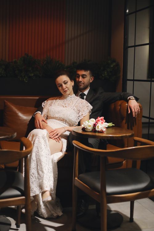 Free A sophisticated couple in evening wear relaxes in an elegant lounge setting, epitomizing modern romance. Stock Photo