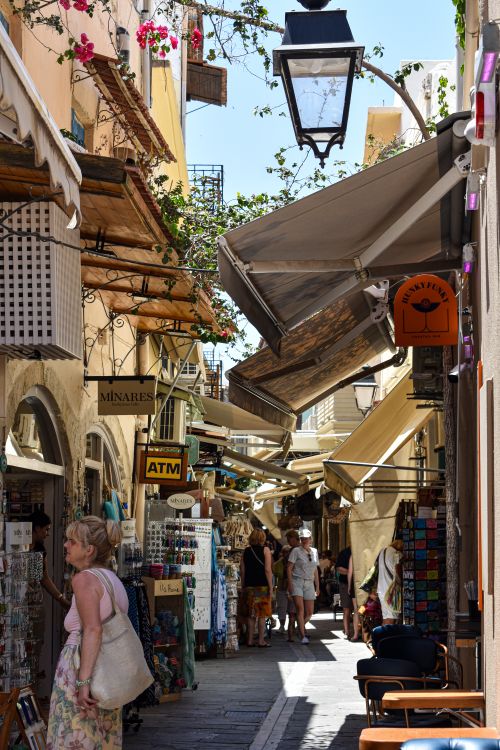 Free A vibrant street in Greece lined with shops and people enjoying a sunny wander. Stock Photo