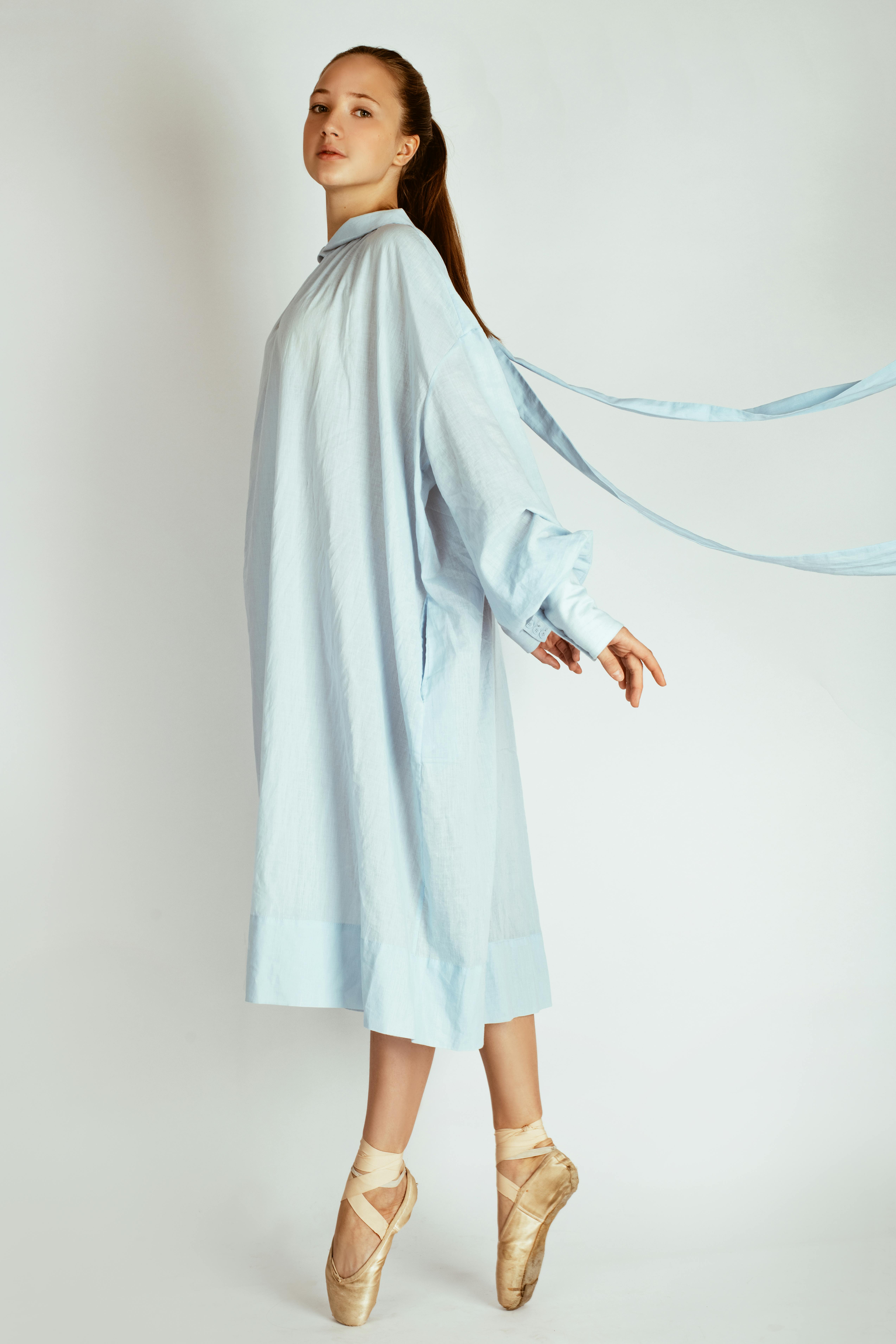 身着飘逸蓝色连衣裙的芭蕾舞演员，姿态优雅而沉着