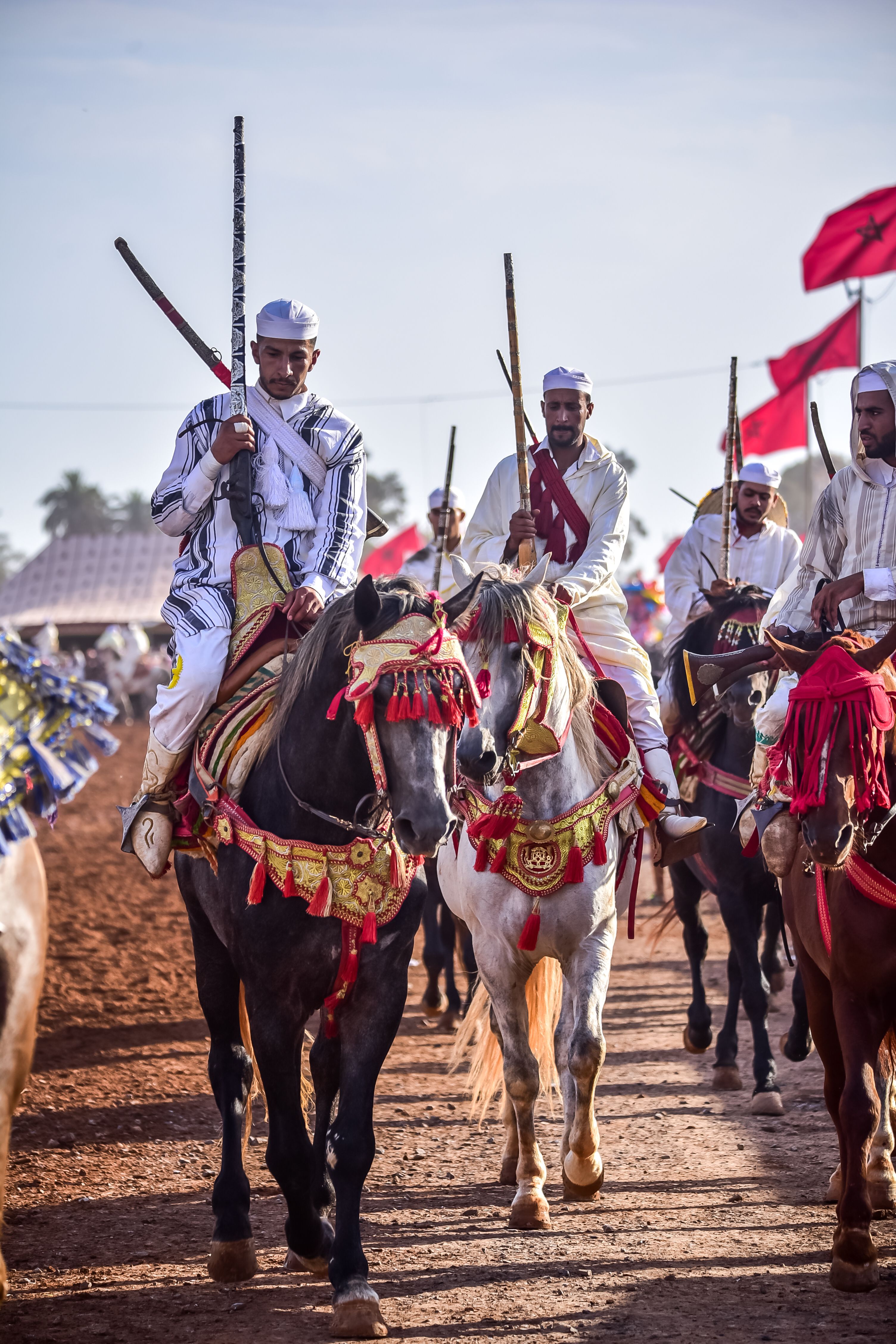 Moroccan horsemen in traditional attire parade at Ain El Aouda festival, showcasing cultural heritage.