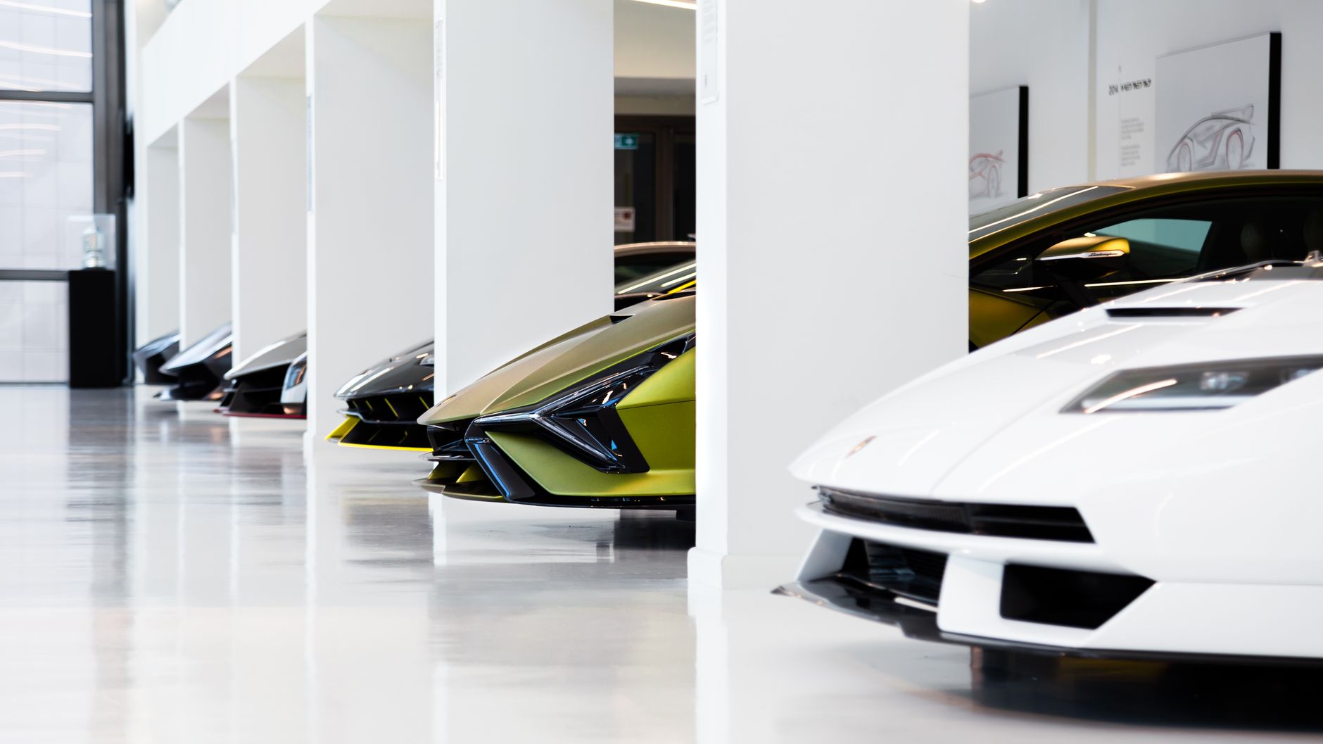 Lineup of high-performance supercars in a bright exhibition hall