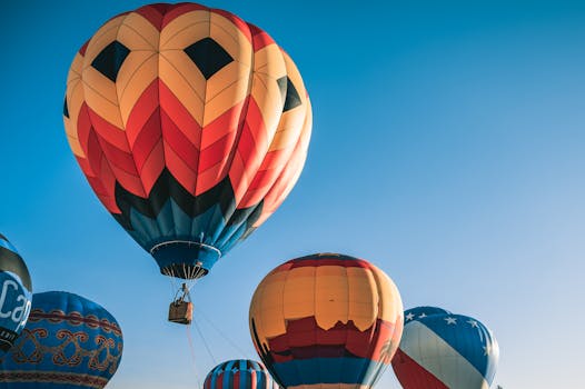Colorful hot air balloons floating in a clear blue sky, perfect for travel enthusiasts.