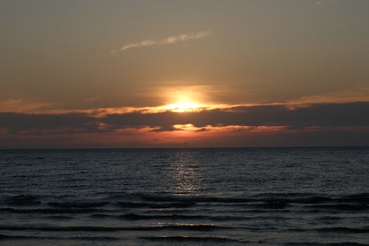 Captivating sunset over the ocean with vibrant orange hues and tranquil waves.