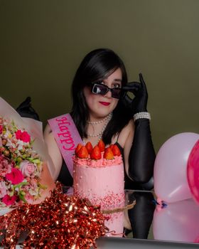 Stylish birthday celebration with pink decor, cake, and flowers, in Mexico City.