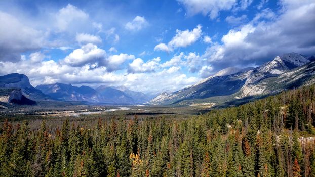 Breathtaking view of the Canadian Rockies with lush forests and dramatic skies in Alberta, Canada.