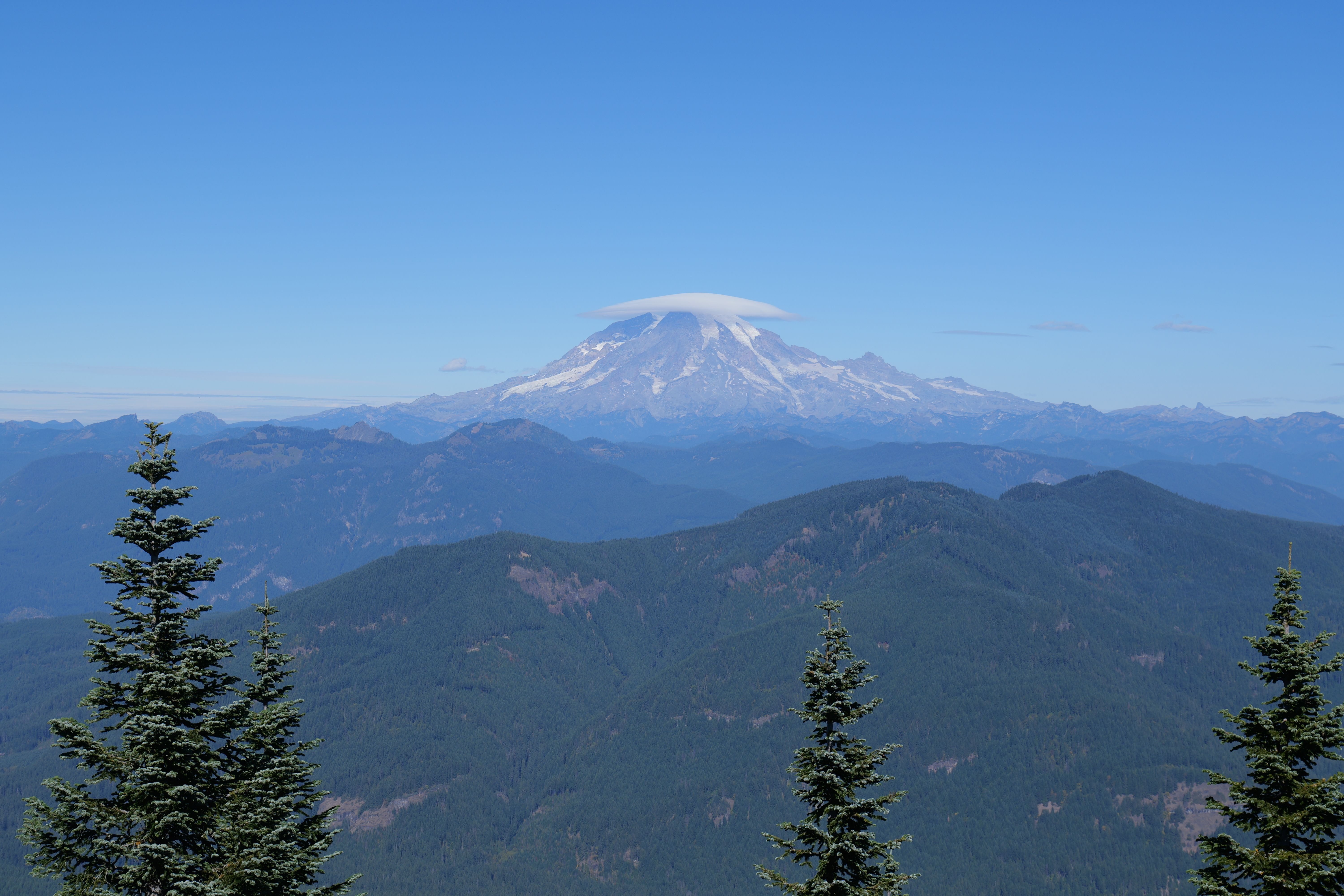 Stunning landscape of Mount Rainier featuring a unique lenticular cloud on a clear day.
