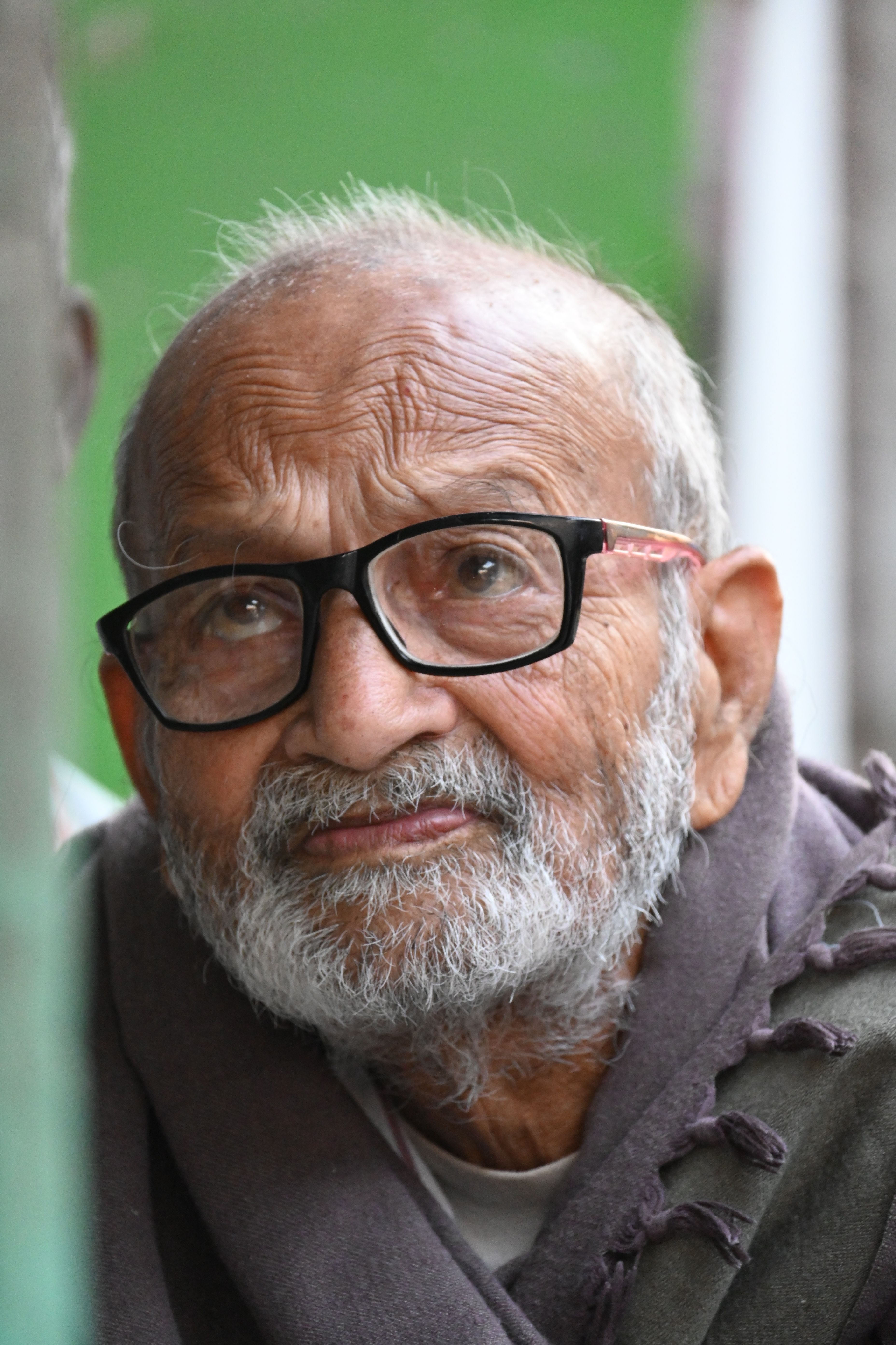Close-up portrait of an elderly man with glasses in Kolkata, India, reflecting deep thought.