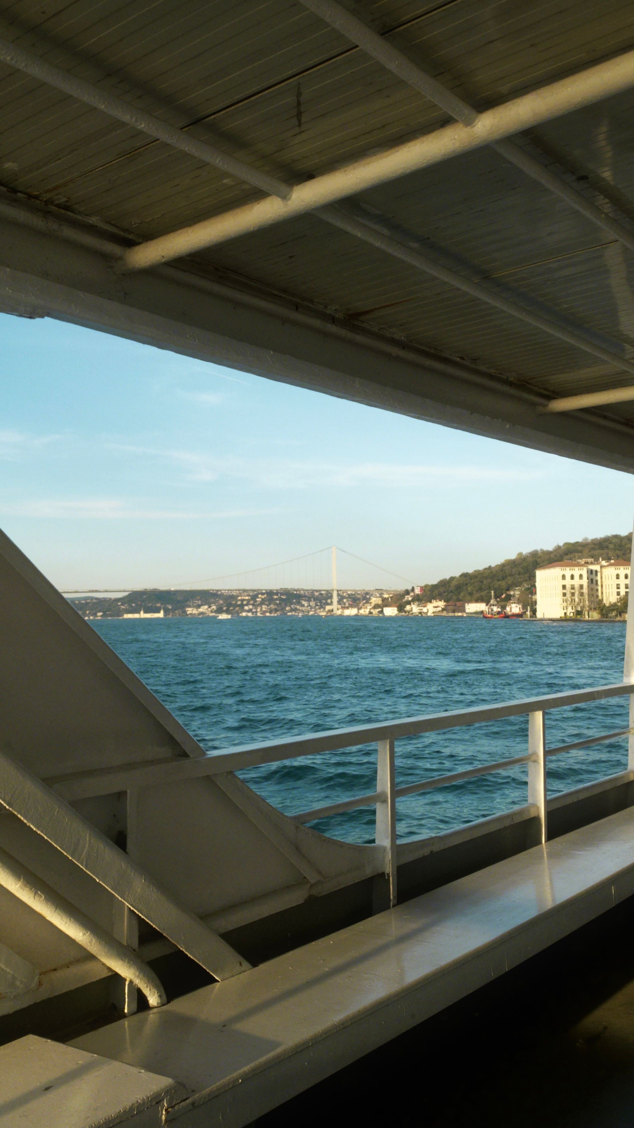 A serene view of the Bosporus Strait from a ferry, with Istanbul skyline.