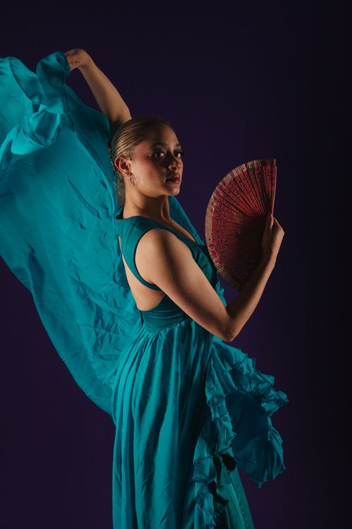 Free Graceful dancer with a fan in a flowing blue dress. Captures elegance and movement. Stock Photo