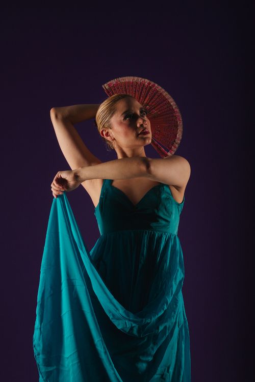 Free Captivating portrait of a woman in a blue dress with a decorative fan. Stock Photo