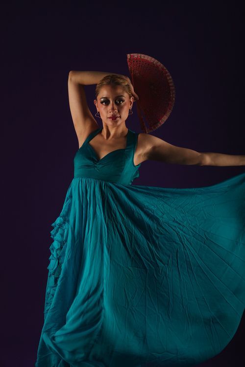 Free Graceful woman in a blue dress holding a fan, under dramatic lighting. Stock Photo