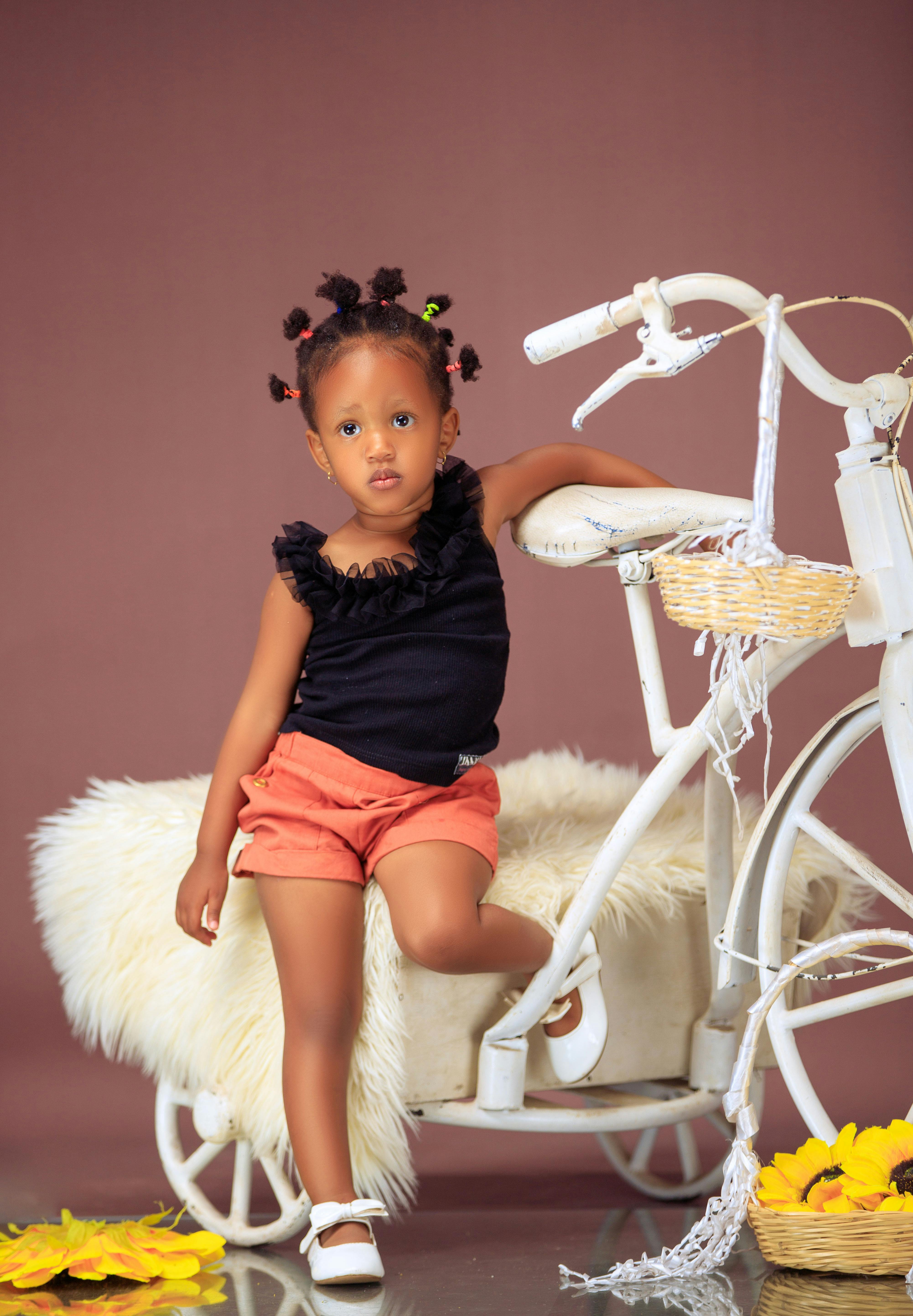 De franc Un nen encantador posant amb una bicicleta blanca vintage en un estudi. Foto d'estoc