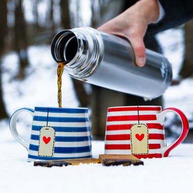 Warm drink poured into striped enamel mugs — photo by Hkn clk on Pexels