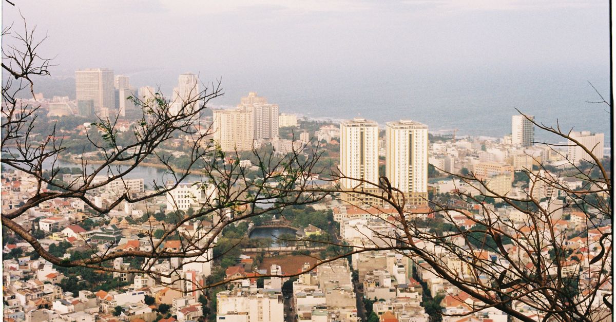 A stunning aerial view of a coastal cityscape with skyscrapers and the ocean in the background.