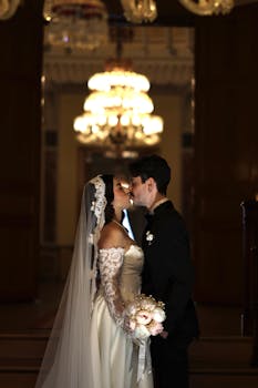 A romantic bride and groom sharing a moment in a luxurious Istanbul palace with grand chandeliers.