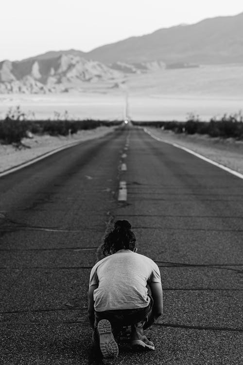 Person Kneeling on Highway