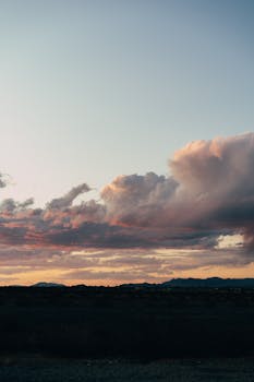 Beautiful sunset with dramatic clouds over a rural landscape, capturing a serene and tranquil evening atmosphere.