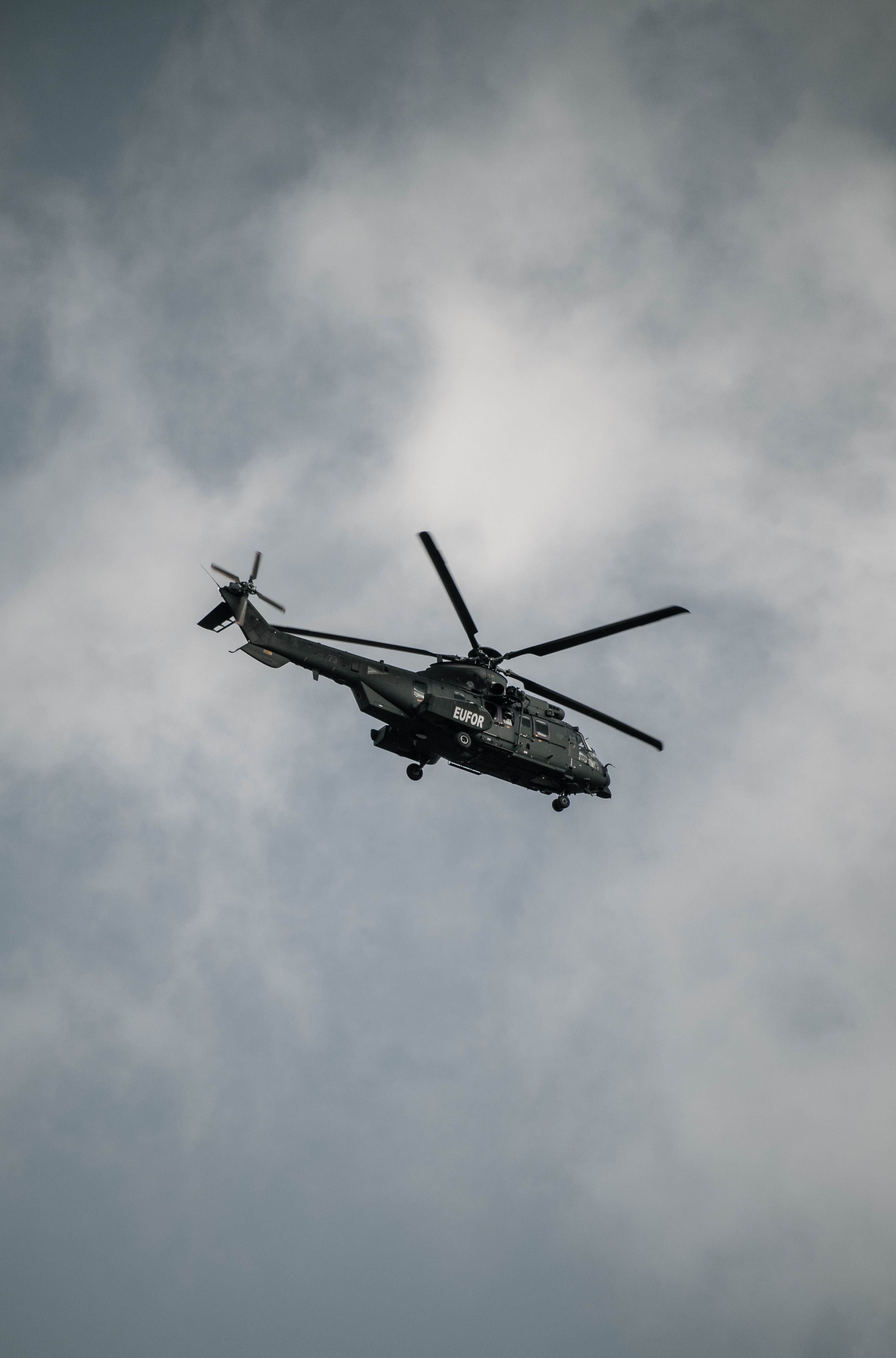 Een militaire helikopter vliegt in de lucht tegen een bewolkte hemel in Sarajevo, Bosnië en Herzegovina.