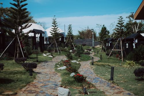 Free Beautiful outdoor garden pathway with trees, shrubs, and dome tents on a sunny day. Stock Photo